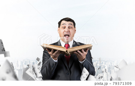 Surprised businessman holding open book 79371309