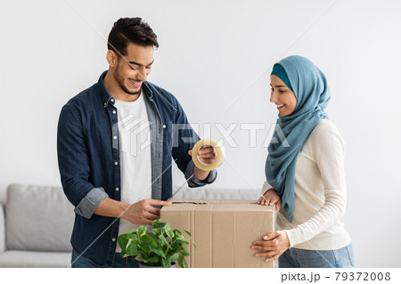 Beautiful young muslim couple moving to new house, packing stuff 79372008