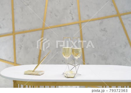 two glasses of champagne on a white table two glasses of champagne on a white table 79372363