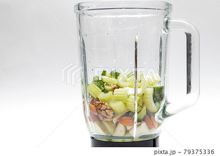 Fresh Celery, avocado, almonds, pears in a glass blender for cooking a green smoothie 79375336
