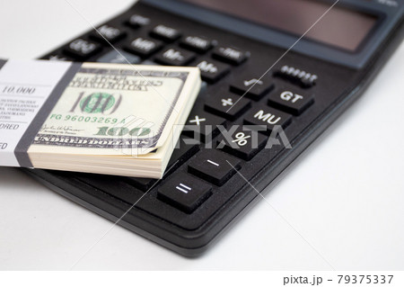 Bundle of dollars and a calculator on a white background 79375337