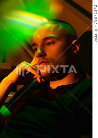 Close-up portrait of handsome young man in neon lighted room, stylish male model indoors 79375342