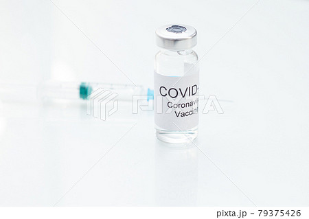 Vial with coronavirus vaccine and syringe on white glass table Vial with coronavirus vaccine and syringe on white glass table 79375426
