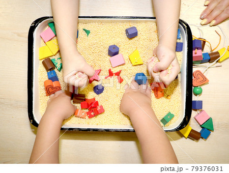 Children playing with kinetic sand, croup and designer in preschool. The development of fine motor concept. Creativity Game concept. Children playing with kinetic sand, croup and designer in preschool. The development of fine motor concept. Creativity Game concept. 79376031