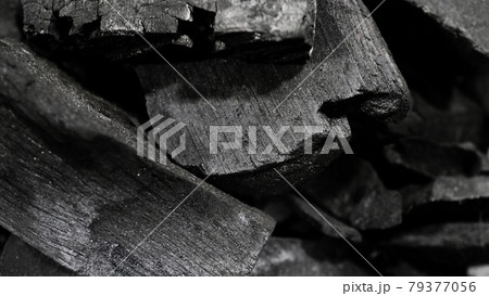 Black Charcoal on black textured floor. charcoal black carbon reesidue produced by strongly heating wood. Used for cooking or other industries. Natural wood charcoal. traditional hard wood charcoal. 79377056