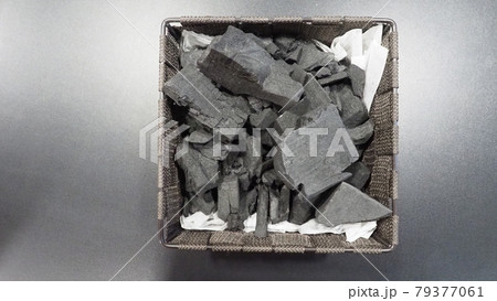 Black Charcoal on black textured floor. charcoal black carbon reesidue produced by strongly heating wood. Used for cooking or other industries. Natural wood charcoal. traditional hard wood charcoal. 79377061