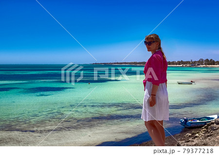 A beautiful girl stands on the shores of the Mediterranean Sea and looks into the distance at the sea A beautiful girl stands on the shores of the Mediterranean Sea and looks into the distance at the sea 79377218
