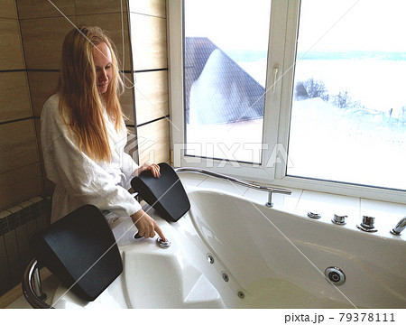Beautiful woman in a hot tub. Jacuzzi in the hotel, panoramic view from the window in the bathroom 79378111