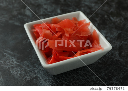 Bowl with red pickled ginger on black smokey background Bowl with red pickled ginger on black smokey background 79378471