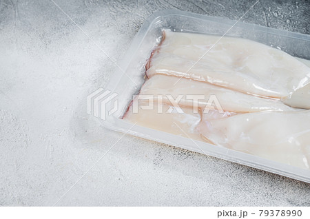 Raw squid or Calamari in a vacuum package from the supermarket. White background. Top view. Copy space 79378990