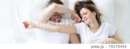 Young man and woman are sleeping on large white bed Young man and woman are sleeping on large white bed 79379493