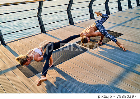 Couple doing practicing yoga together on nature outdoors . Morning exercises at the sunrise. Couple doing practicing yoga together on nature outdoors . Morning exercises at the sunrise. 79380297