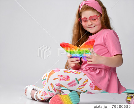 Happy little red-haired girl child rejoice pop it Happy little red-haired girl child rejoice pop it 79380689