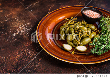 Marinated canned Capers berries in a rustic plate. Dark background. Top view. Copy space Marinated canned Capers berries in a rustic plate. Dark background. Top view. Copy space 79381353