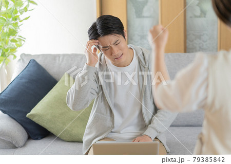 自宅のリビングで妻に叱られる夫 79385842