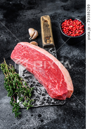 Fresh Raw top sirloin beef meat steak on a butcher cleaver. Dark wooden background. Top view 79386299