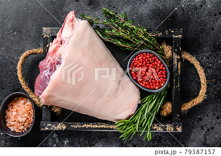 Fresh Raw pork Eisbein knuckle ham in a wooden tray with meat knife. Black Wooden background. Top view 79387157