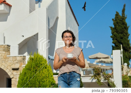 Beautiful happy smiling woman walking with cup of coffee 79390305
