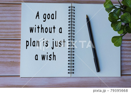 Motivational quote on notepad on wooden table 79395668