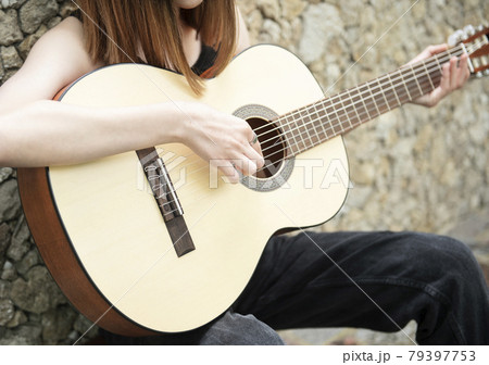 Teenage girl with a guitar 79397753