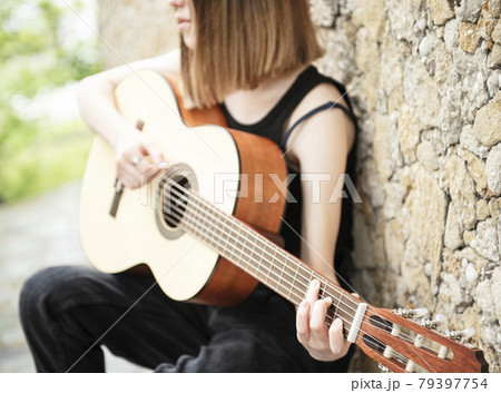 Teenage girl with a guitar 79397754