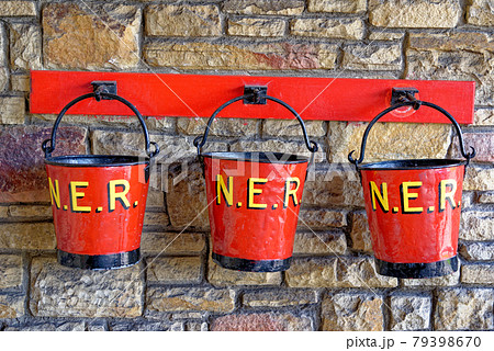 Three red fire buckets on the station platform on the Rowlew Train Station 79398670