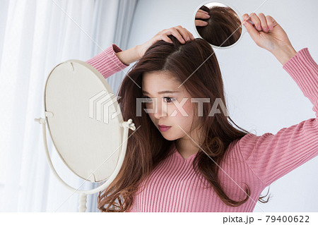 鏡で頭頂部を見る女性 79400622