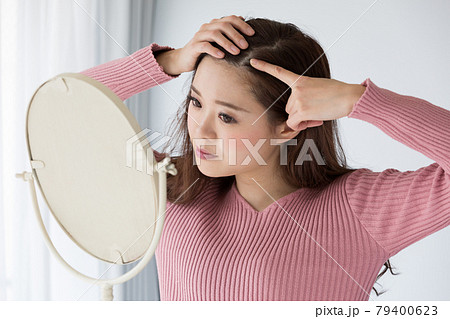 鏡で頭皮を見る女性 鏡で頭皮を見る女性 79400623