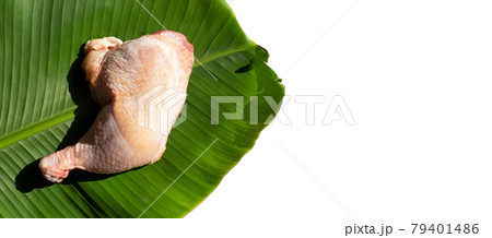 Raw chicken leg on banana leaf on white background Raw chicken leg on banana leaf on white background 79401486