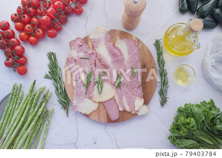 Raw fed bacon strips on chopping board . 79403784