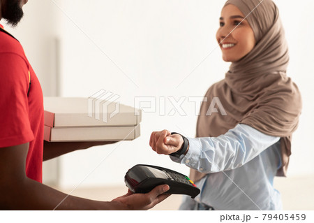 Black deliveryman holding pizza boxes and pos terminal 79405459