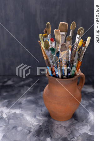 Paint brush in clay jug on abstract table background . Paintbrush for painting art still life Paint brush in clay jug on abstract table background . Paintbrush for painting art still life 79405669