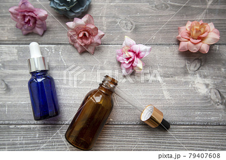 bottles with a dropper of hyaluronic serum and cosmetic containers for beauty procedures on a wooden background with flowers. beauty and skin care 79407608