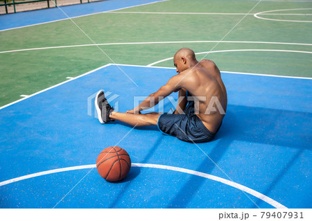 Young strong man, male basketball player practicing at street public stadium, sport court or palyground outdoors. Concept of healthy active lifestyle, motion, hobby. 79407931