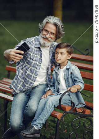 Grandfather with grandchild sitting in a summer park 79407998