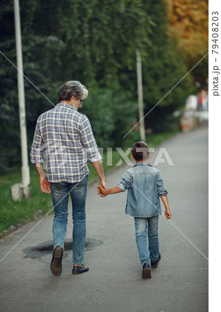 Grandfather with grandchild walking in a summer park 79408203