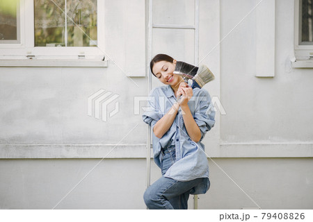 Cute girl standing near wall with repair tools Cute girl standing near wall with repair tools 79408826