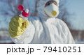Man in protective costume and glove constricts plastic bottle 79410251