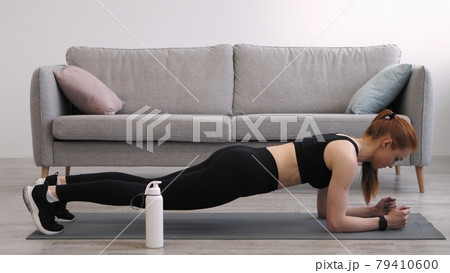 Female Doing Elbow Plank Exercise Training At Home, Wearing Fitwear Female Doing Elbow Plank Exercise Training At Home, Wearing Fitwear 79410600