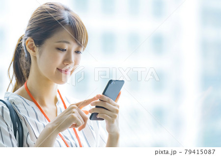オフィスでスマホを操作する若いビジネスウーマン オフィスでスマホを操作する若いビジネスウーマン 79415087