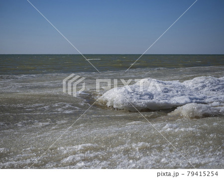 Sea waves made of snow and ice porridge. Blocks of ice and snow float in the sea and form intricate shapes. Sea water in winter. 79415254