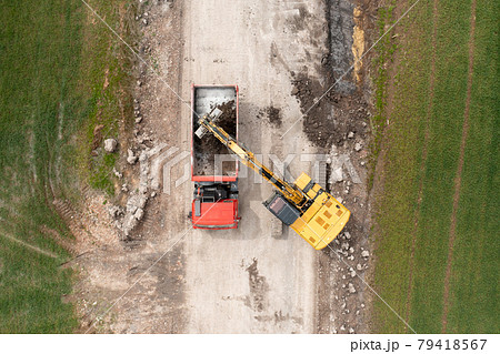 Excavator digging ground near the field and loading to the truck Excavator digging ground near the field and loading to the truck 79418567