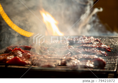 in the evening, delicious juicy steaks on an open fire are grilled on a barbecue grill. close-up, soft focus. smoke is highlighted in the evening, delicious juicy steaks on an open fire are grilled on a barbecue grill. close-up, soft focus. smoke is highlighted 79421072