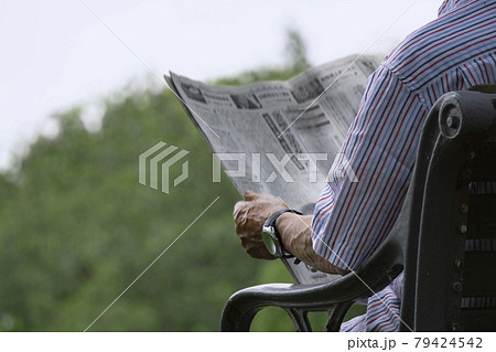 公園のベンチで新聞を読んでいる高齢者または中高年 79424542