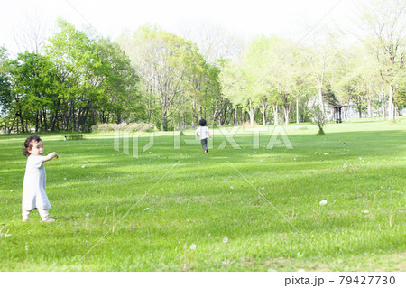 緑の公園で遊ぶ兄妹 緑の公園で遊ぶ兄妹 79427730