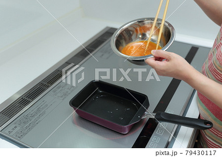 IHクッキングヒーターの上で卵焼きを作る主婦の女性 IHクッキングヒーターの上で卵焼きを作る主婦の女性 79430117