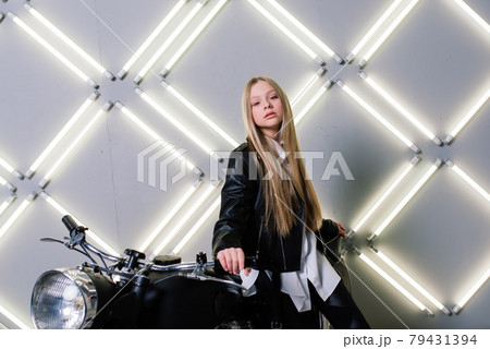Young fashion girl posing in black leather with motorcycle. 79431394