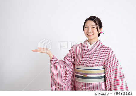 小紋を着て手を上げて案内をしている若い日本人女性 小紋を着て手を上げて案内をしている若い日本人女性 79433132