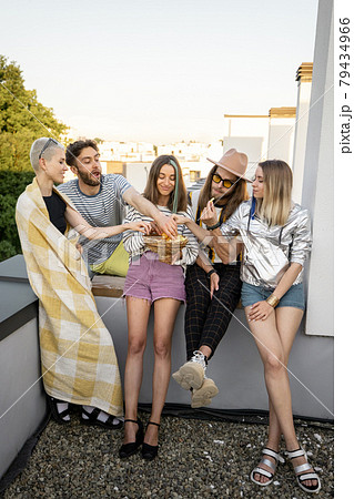 Friends hang out together at rooftop on a sunset 79434966