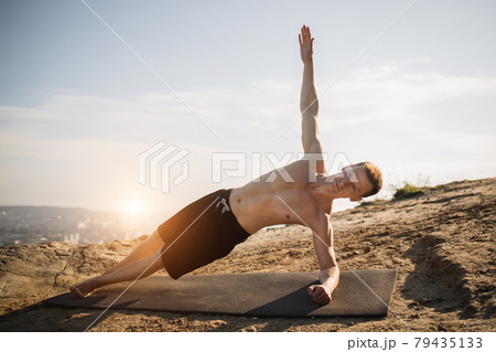 Sporty young man with naked torso doing exercises for abs Sporty young man with naked torso doing exercises for abs 79435133